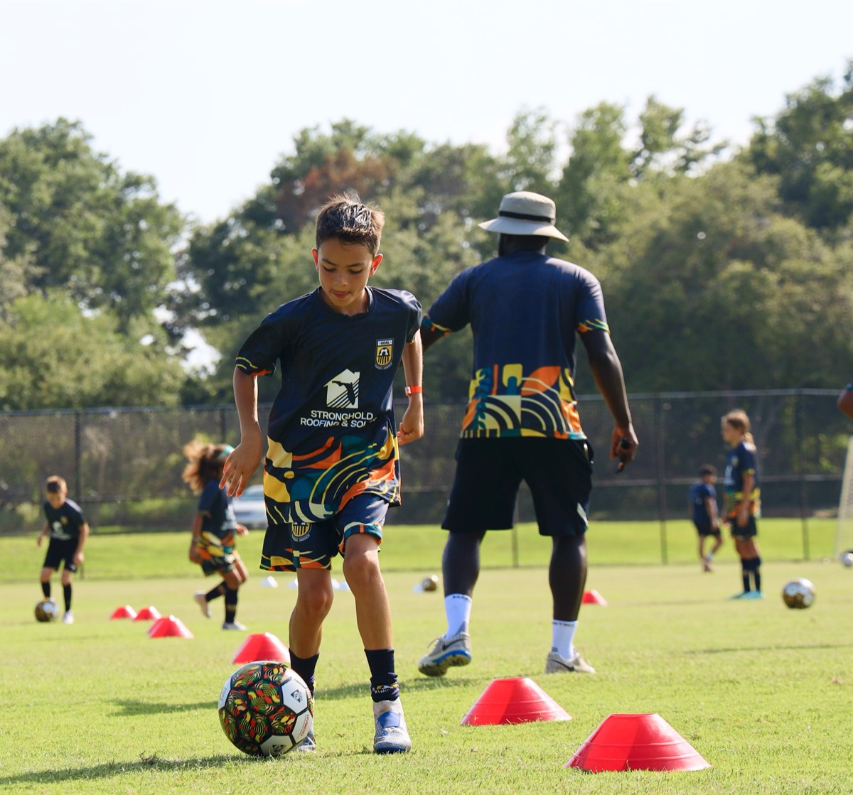 Youth player practicing cone drills with Coach Melvin