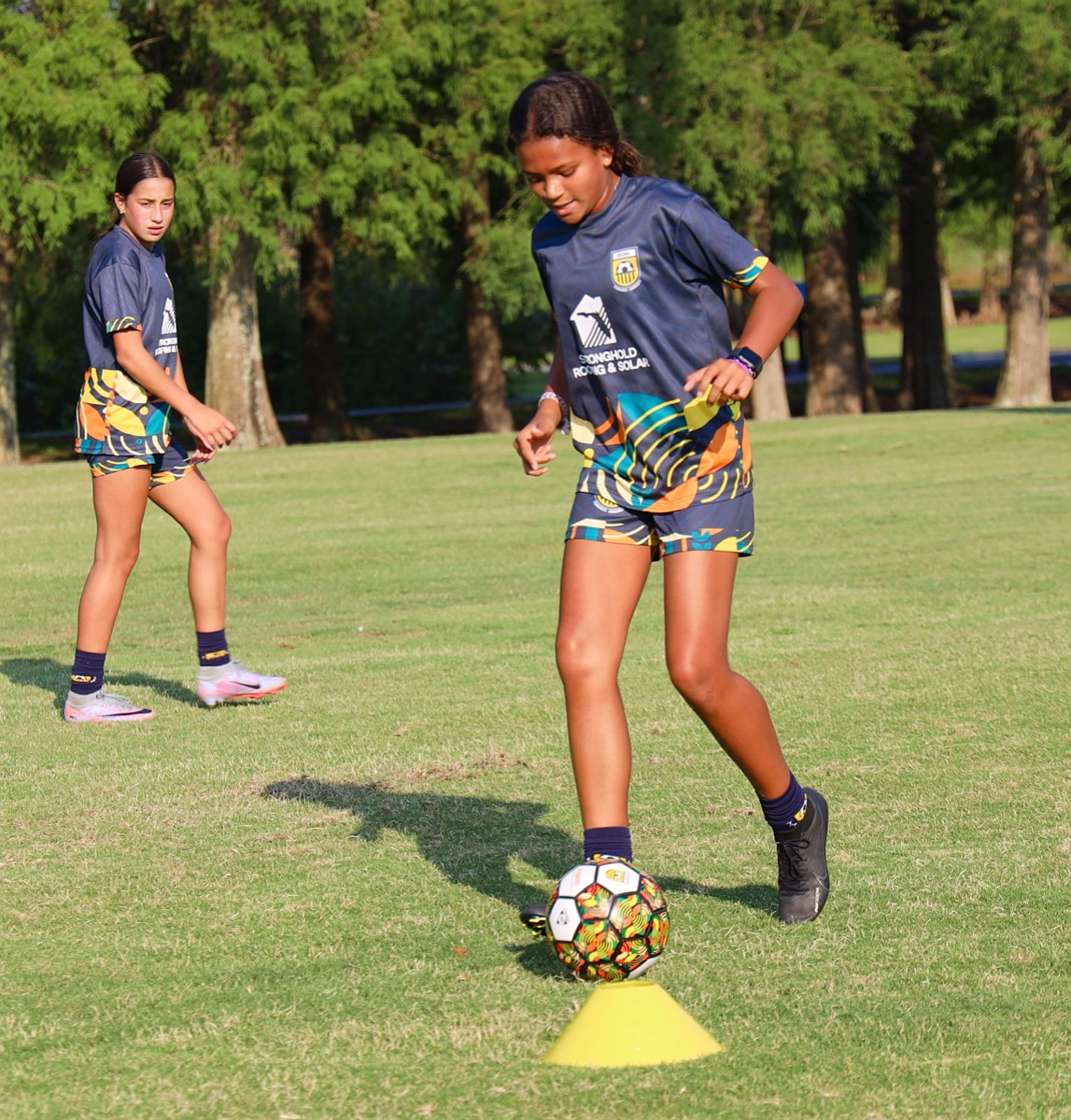 Athletes practicing ball control through cone drills