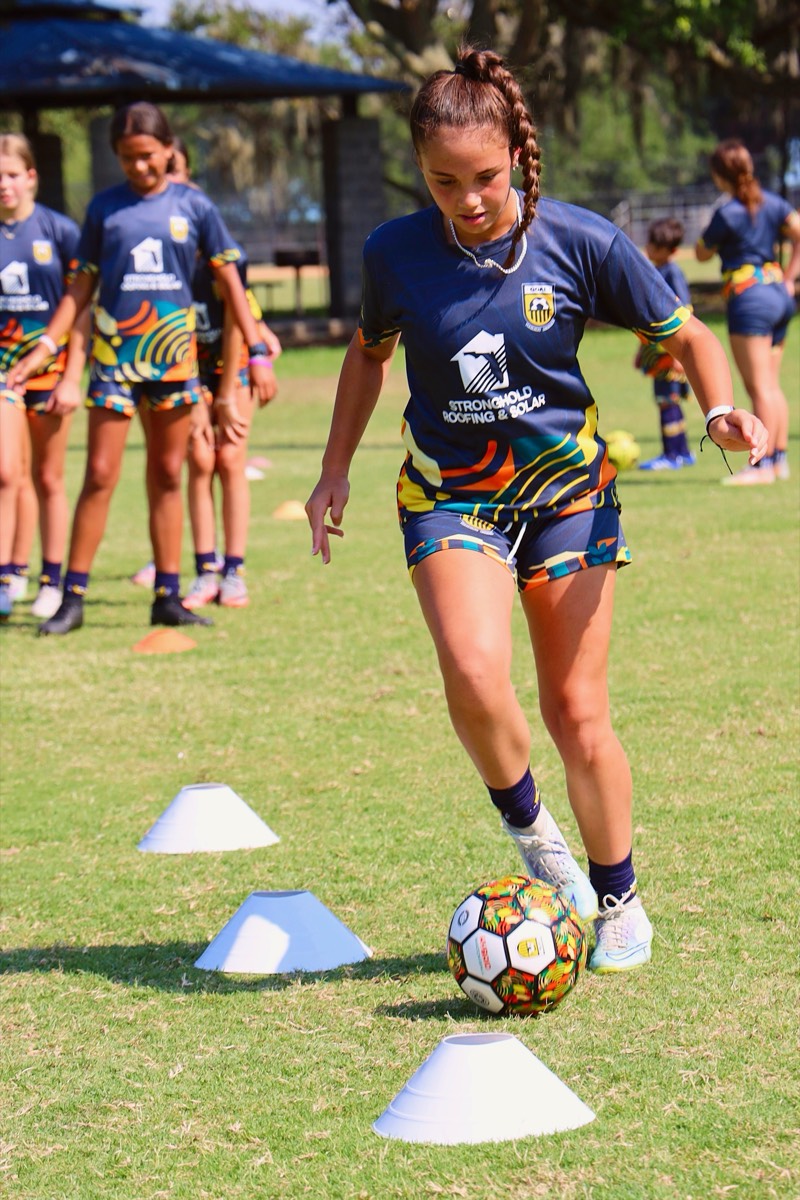 Player dribbling through cones during training session